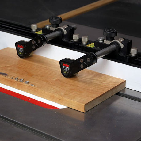 JessEm stock guides on a table saw fence holding a cherry board flat against the fence