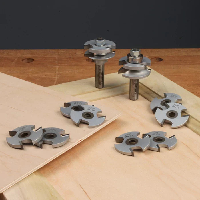 Woodworking router bit set with slot cutting blades on a wood workbench