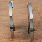 Two woodworking saw blades with carbide tips standing upright on a wooden surface