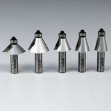 Five carbide-tipped router bits for woodworking displayed in a row on a plain background