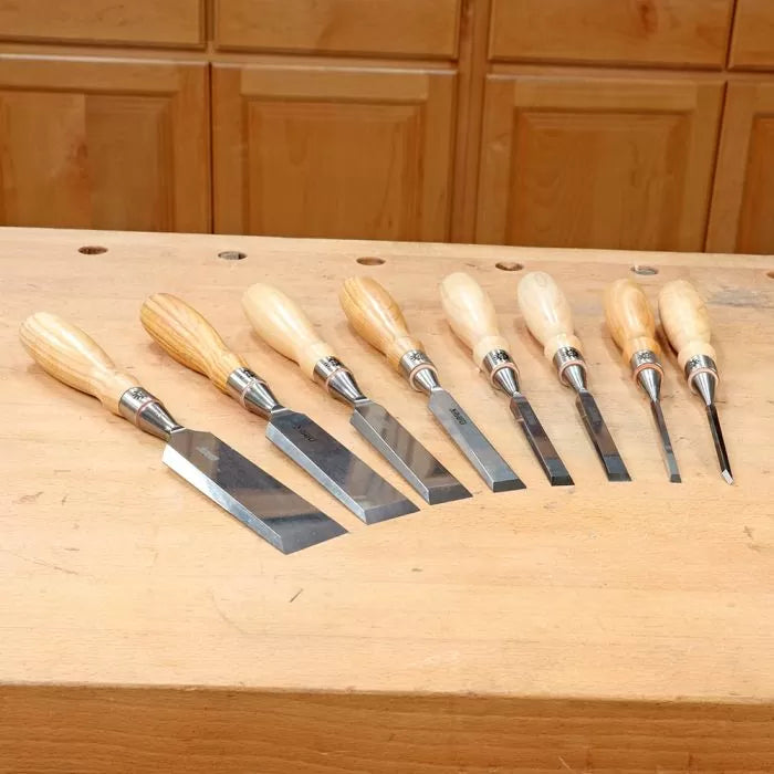 Set of wood chisels with wooden handles on a workbench, woodworking hand tools