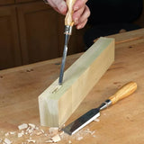 Woodworking hand chisels carving mortise in timber on a workbench with wood shavings