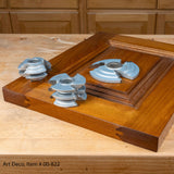 Art Deco shaper cutter set displayed on a wooden cabinet door panel, woodworking tools