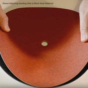 Attaching a sanding disk to black hook material for woodworking sanders