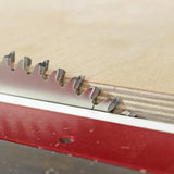 Close-up of a table saw blade cutting plywood for precise woodworking.
