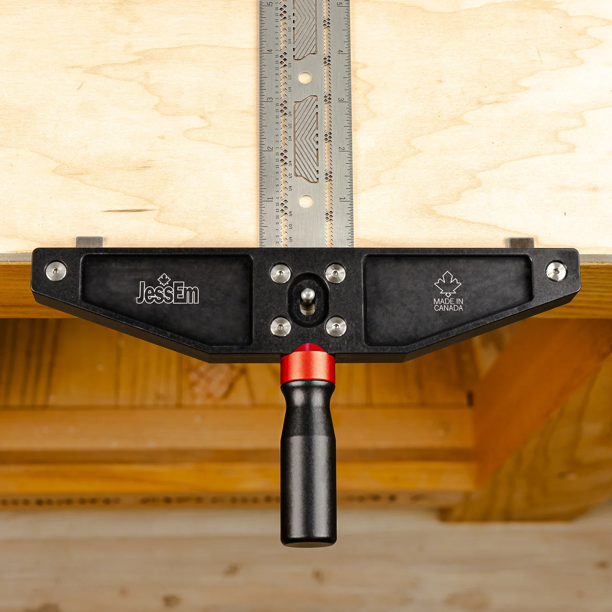 Woodworking clamp with JessEm logo attached to a workbench and metal measuring guide