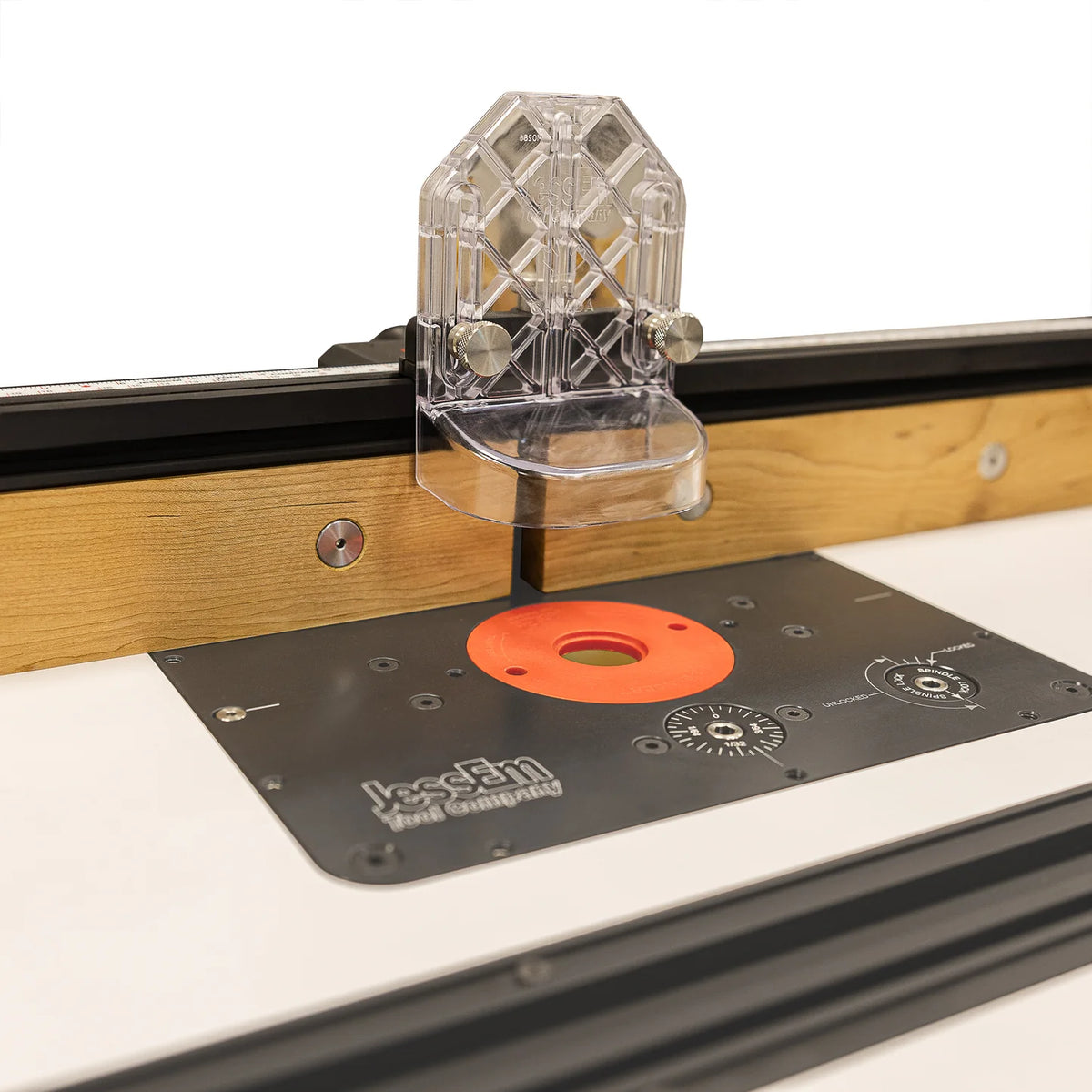 Woodworking router table with adjustable fence and clear safety guard for precise cutting