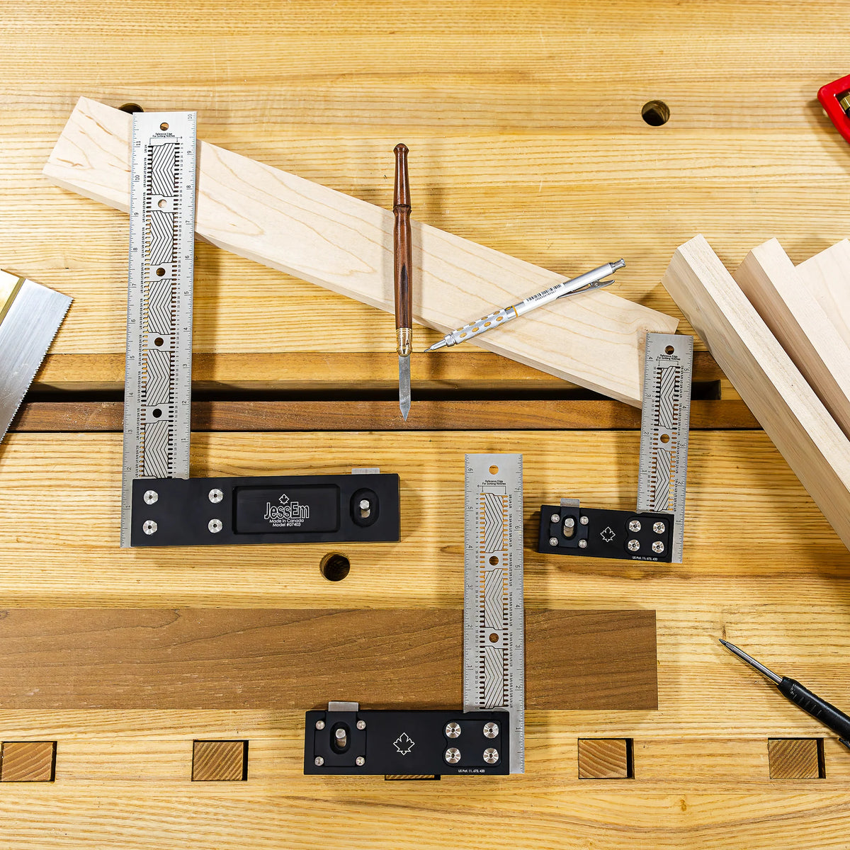 Set of precision woodworking squares and rulers on a workbench with wood pieces and marking tools