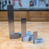 Set of four precision steel woodworking squares on a workshop bench