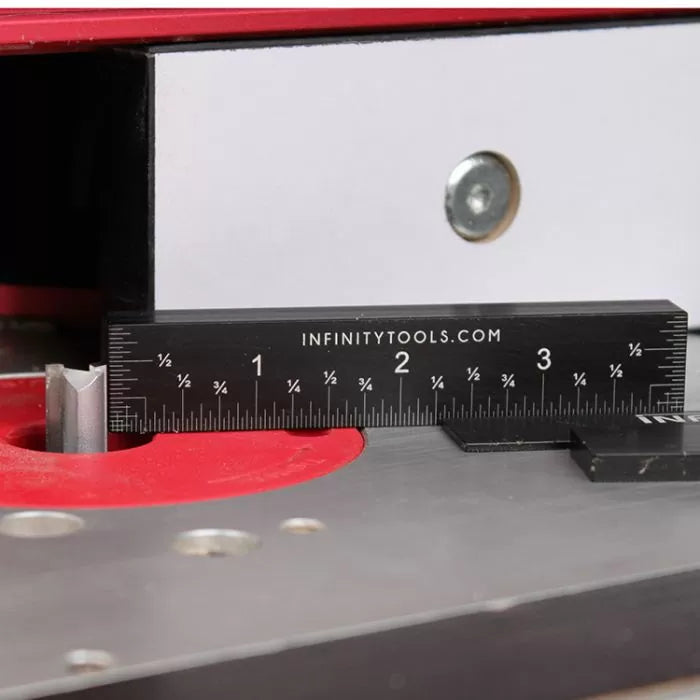 Router table setup with steel ruler measuring router bit height for woodworking precision.