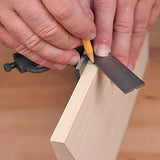 Using a combination square to mark a precise line on a piece of wood for woodworking.