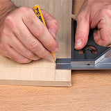 Hand using a combination square and pencil to mark precise lines on a wood board
