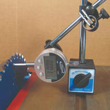 Digital dial indicator with magnetic base measuring saw blade runout on a metal table