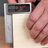 Hand using a combination square to measure and mark wood for precise woodworking