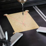 Drill press with laser guide aligns for precise wood drilling on marked board