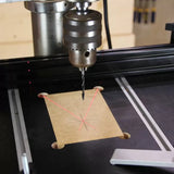 Drill press with crosshair laser guide aligning on marked wood for precision drilling