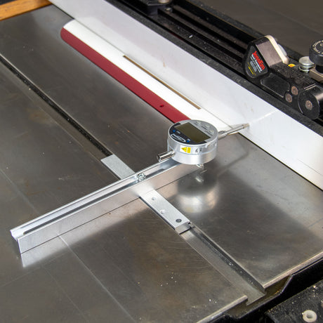 Digital measuring gauge setup on a table saw to measure table saw fence straightness.