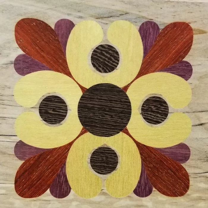 Geometric floral wood inlay design with yellow, brown, and reddish tones on light wood background