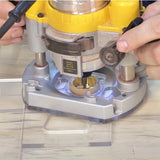 Handheld woodworking router with guide bushing in use on clear base plate