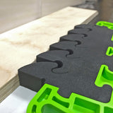 Foam bench dog pad with green frame holding plywood, woodworking accessory for workbenches