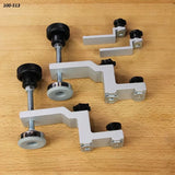 Set of adjustable woodworking hold-down clamps on a wooden workbench surface