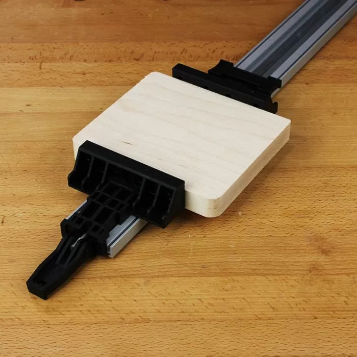 Woodworking clamp jig holding square wood piece on workbench