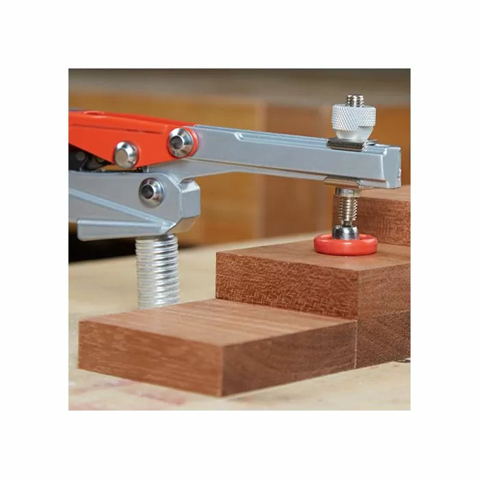 Toggle clamp securing stacked wooden blocks on a workbench for woodworking projects