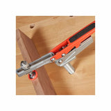 Toggle clamp securing wooden board on workbench for woodworking projects