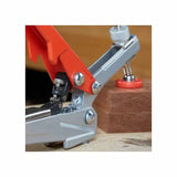 Toggle clamp securing a wood block on a workbench, woodworking tool close-up
