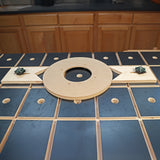 Woodworking circle cutting jig on workbench with cabinetry in background