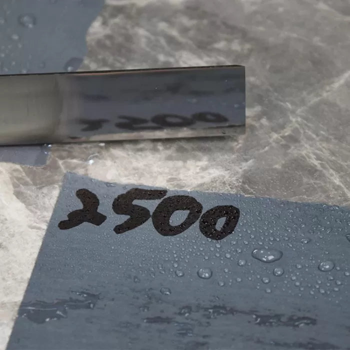 Polished chisel on wet 2500 grit sharpening stone for woodworking tool honing