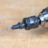 Close-up of a drill with a countersink bit and depth stop on a wooden workbench