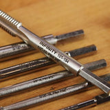 Close-up of metal thread cutting taps for woodworking on a wooden surface