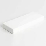 Rectangular white sharpening stone for woodworking tools on a plain background