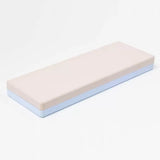 Double-sided sharpening stone with beige and blue layers on white background