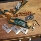 Wood hand plane with disassembled parts and accessories on a workbench with wood shavings