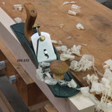Bench hand plane on woodworking bench surrounded by wood shavings, labeled 101-572