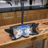 Miter trimmer woodworking tool on workbench surrounded by wood strips in workshop setting