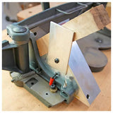 Woodworking miter sled jig holding a wood piece at an angle on a workbench