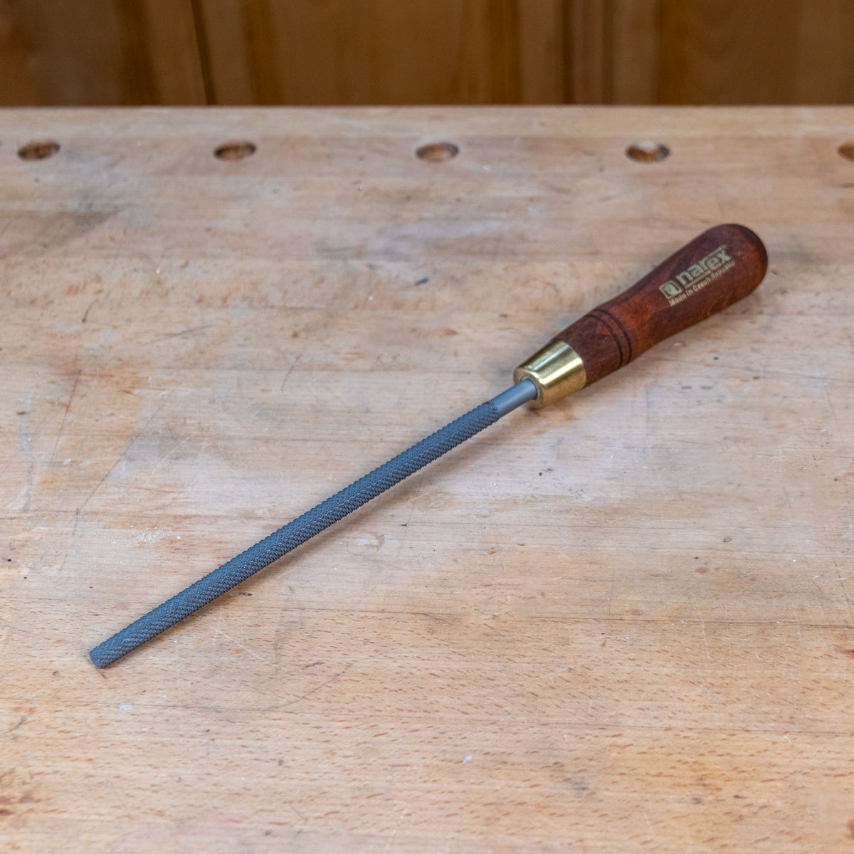 A round rasp on a wooden work bench.