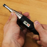 Hands holding an adjustable torque screwdriver on a wooden surface