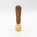 Brass woodworking mallet with a wooden handle on a white background