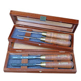Woodworking chisel set with wooden handles in two open wooden cases, foam inlays visible.