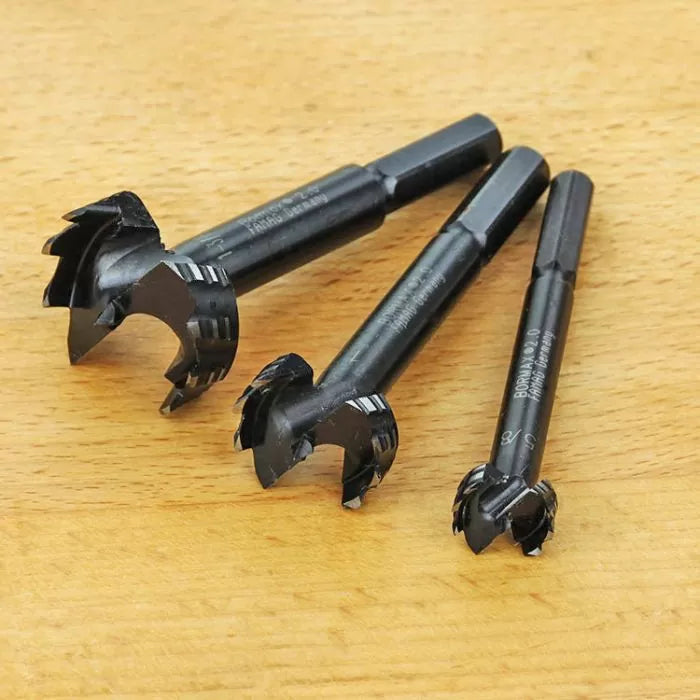 Set of three Forstner drill bits for woodworking on a wooden surface