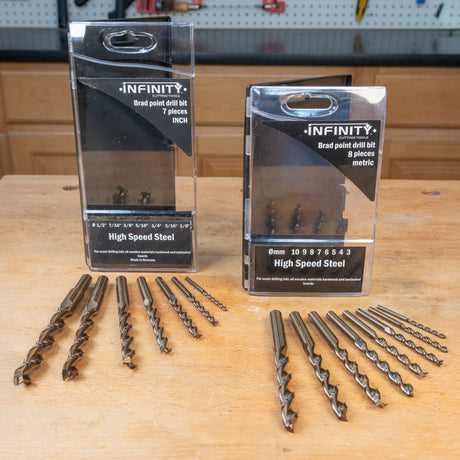 High speed steel brad point drill bit sets in inch and metric sizes on workbench
