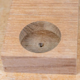 Cleanly drilled hole in a wooden block, showcasing precise woodworking technique