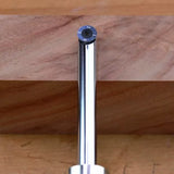 Round carbide insert router bit positioned against a wooden board for woodworking.