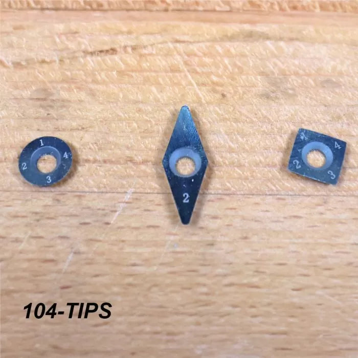 Three replaceable carbide cutter tips in round, diamond, and square shapes on a wood surface