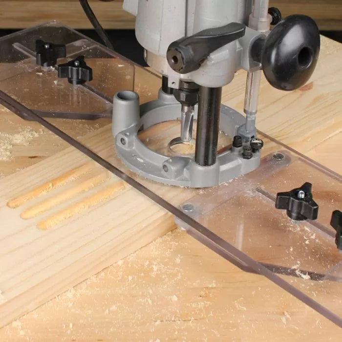 Woodworking router with clear guide making mortises in a pine board on a workbench
