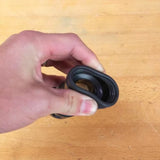 Hand holding flexible rubber dust collection fitting for woodworking tools on a workbench